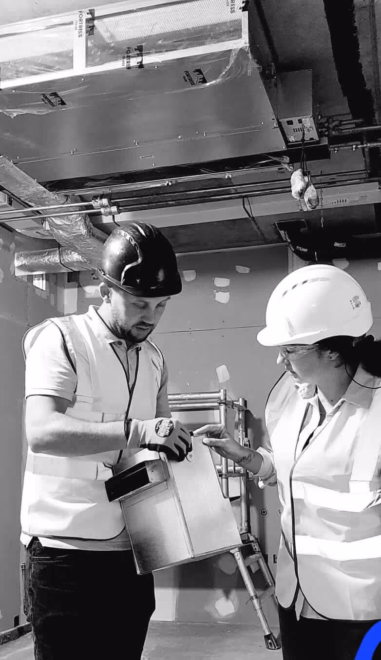 Domani Ventilation engineers surveying an MVHR plenum on a London construction site