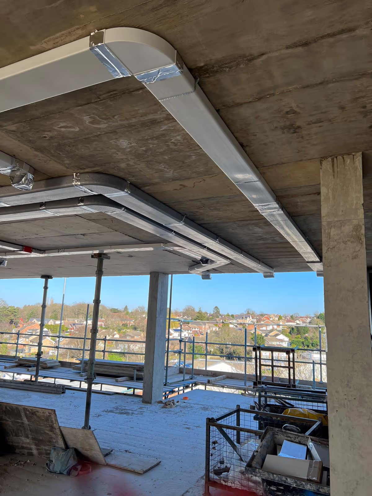 Commercial ductwork routing with city views during a London office fit-out